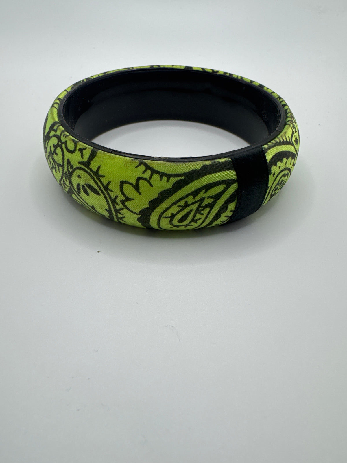Wide lime green bangle bracelet featuring a black doodle-style line art pattern
