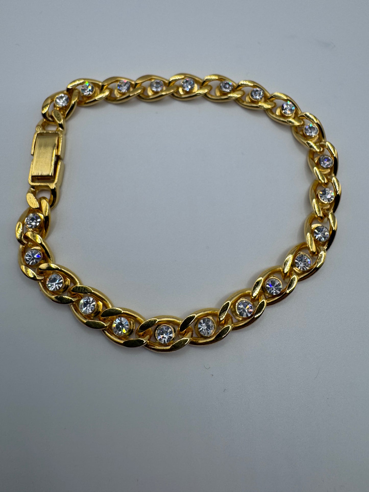 gold-tone curb link bracelet featuring sparkling clear rhinestones